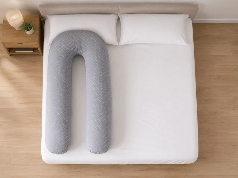 Tweepersoonsbed van bovenaf, met het U-kussen op één kant van het matras